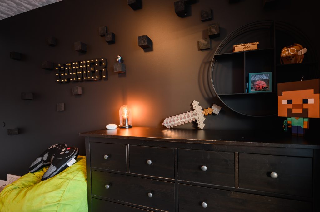 male bedroom designed for gamer with dark colour scheme