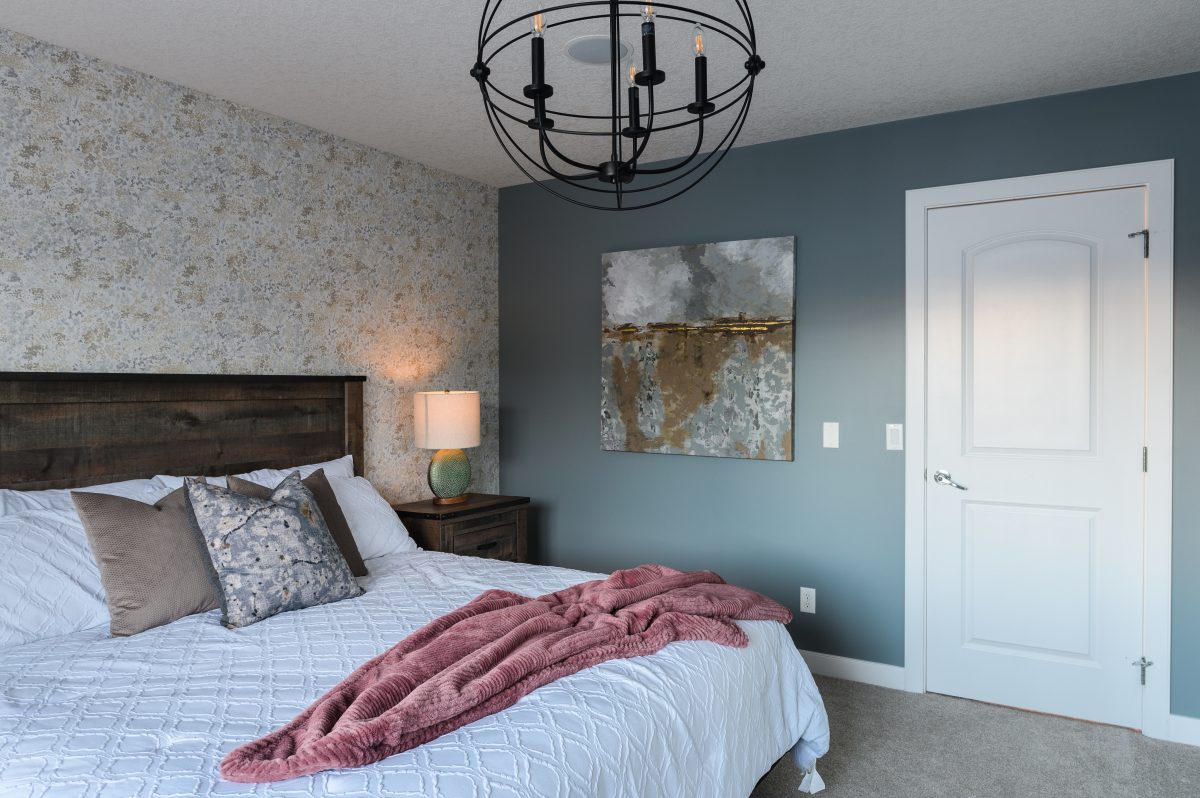 gold artwork used to compliment the wooden bed frame and side table as well as the accent wallpaper