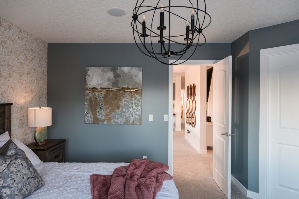modern farmhouse master bedroom with grey-blue walls, and soft toned wallpaper that is accentuated by the artwork