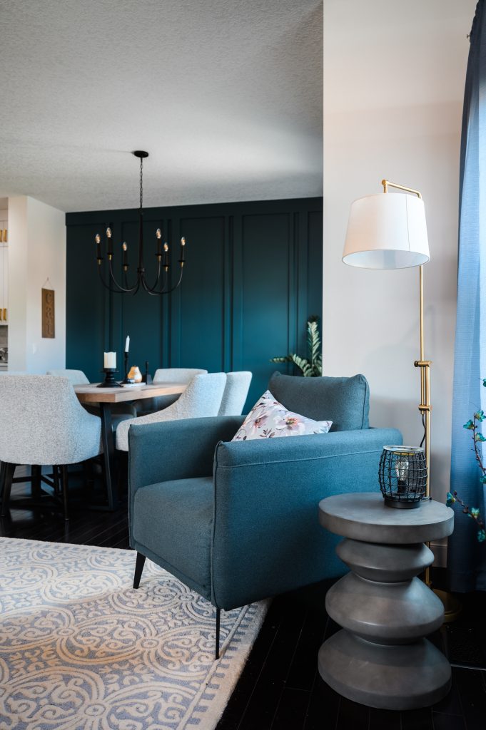 a navy blue reading chair that accents the dining room wall and curtains