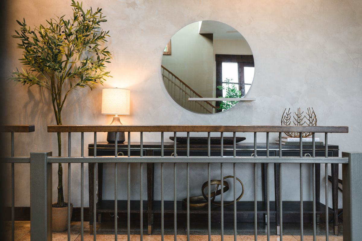 style a blank wall with a narrow table, plant, chair, and decor that compliments the space