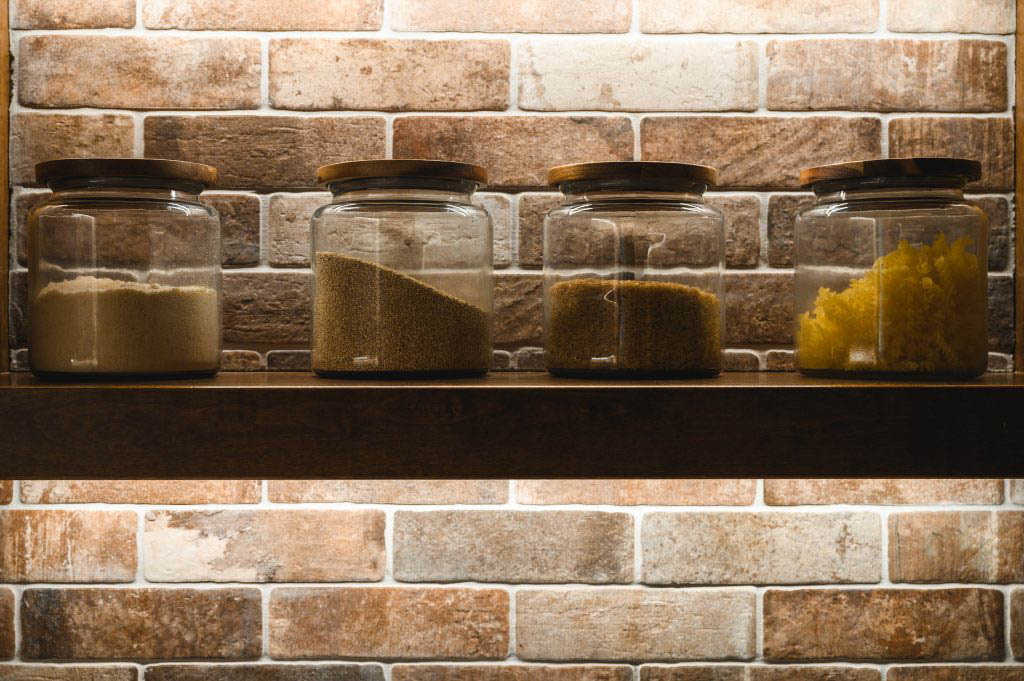 glass containers filled with dry foods topped with wooden lids to accent the wood in the home