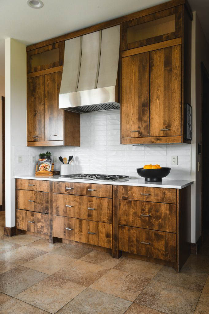 a relaxing cooking station due to the warm wood tones and the shimmering white tiled backsplash