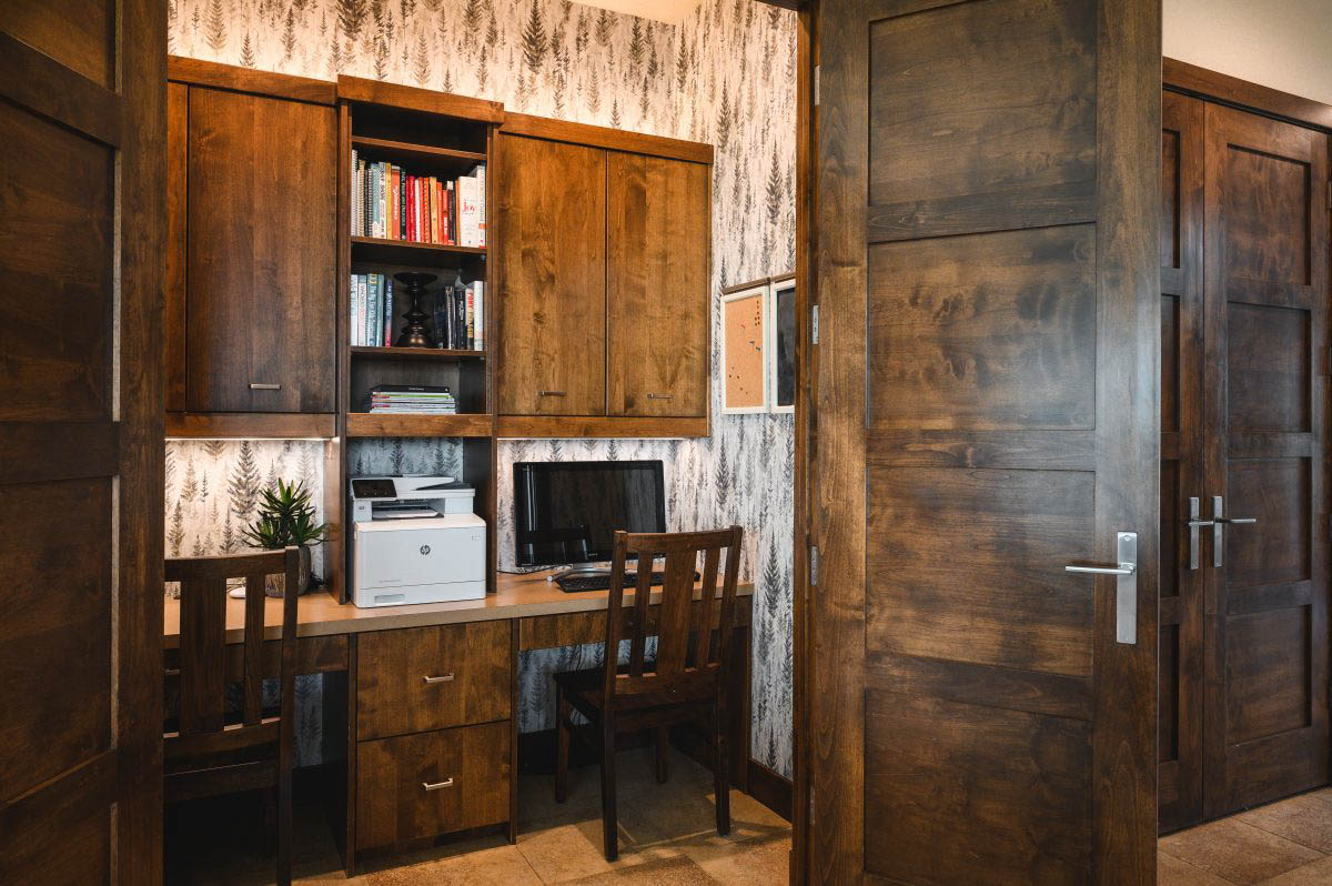 a closet workstation with wallpaper to accent the wood cabinetry