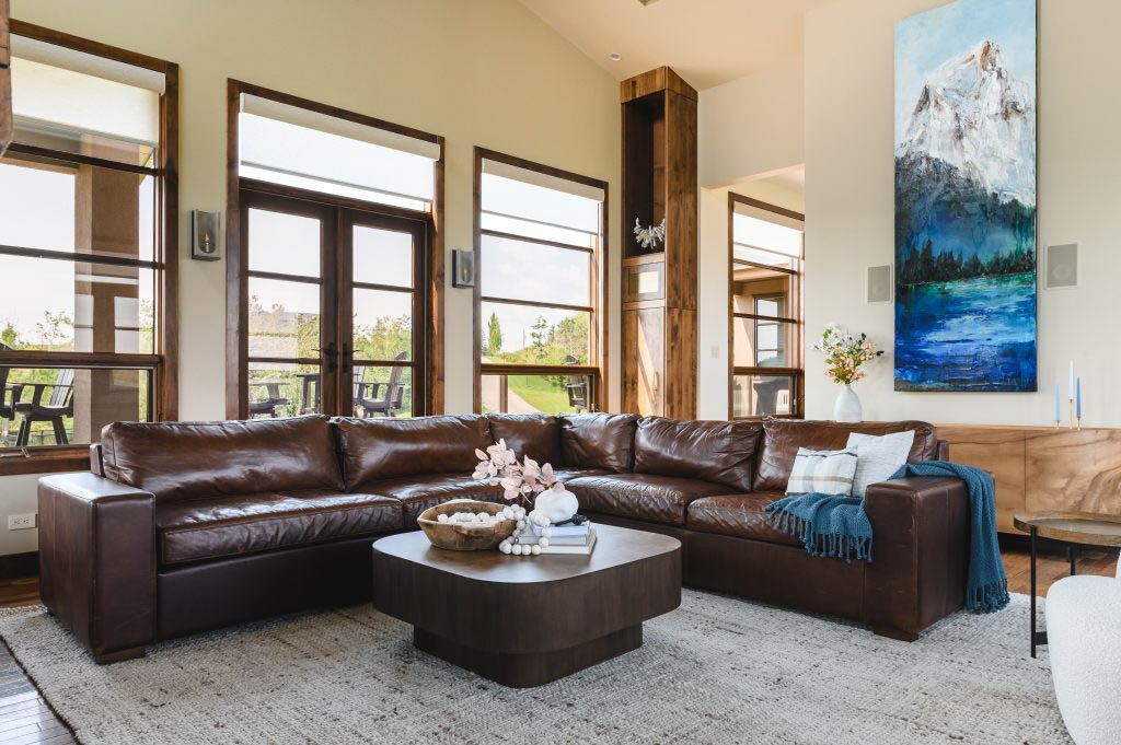 a large brown leather sectional, styled with a large light area rug for proper colour dimensions