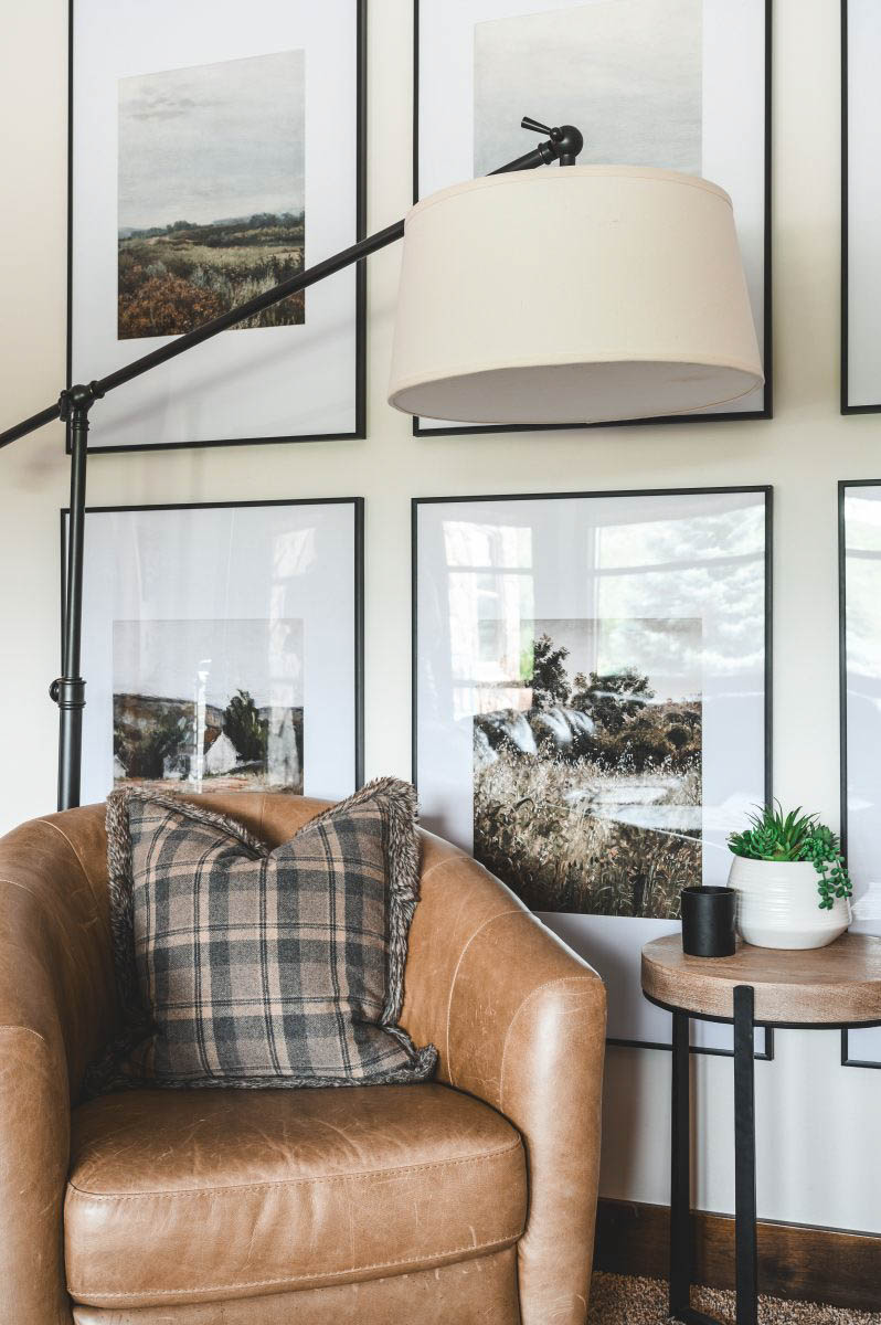 a light brown, orange toned leather chair, style with plaid pillow to accent the frames and table