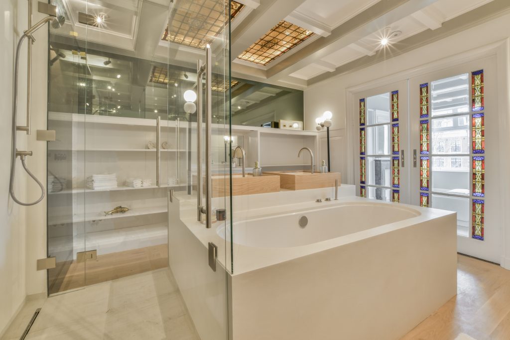 Interior of contemporary bathroom with shower, bathtub and sink in minimal style in flat