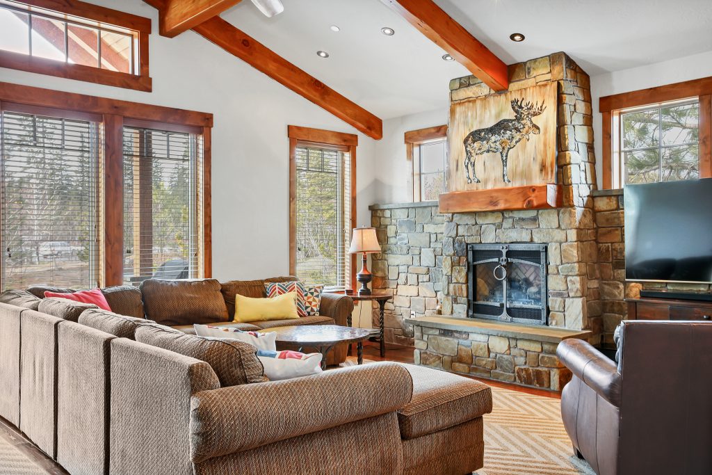 Light spacious living room with stone fireplace.