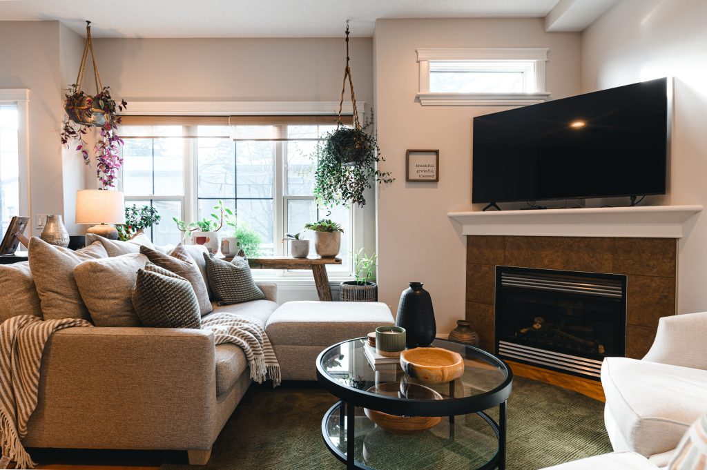 Cozy luxury killarney home interior decorating Living Room large sectional unshelf design. Living room with large windows and lots of plants.