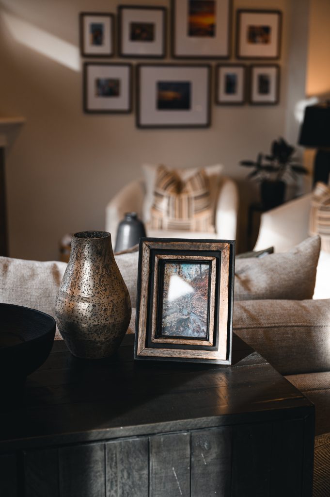 Cozy luxury killarney home interior decorating Living Room styling detail unshelf design. Brass and black decor styled on top of a dark wood table.