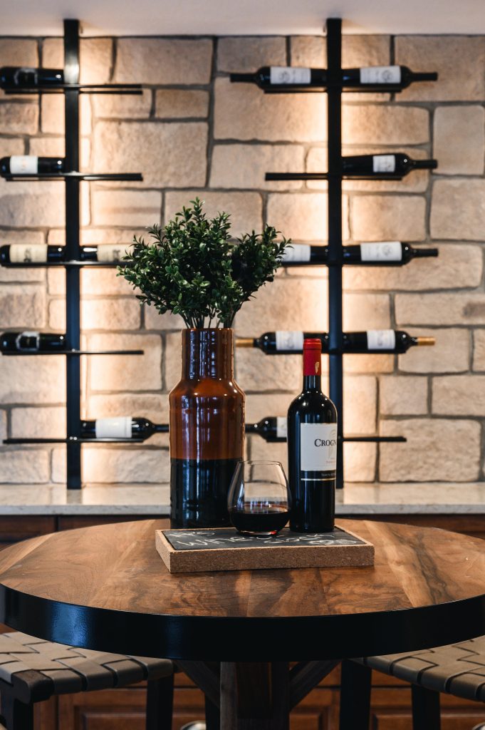 Tuscany Estate Interior Decorating Wine Tasting Room Table Styling Unshelf Design. Table top decorated with large vase and bottle of wine.