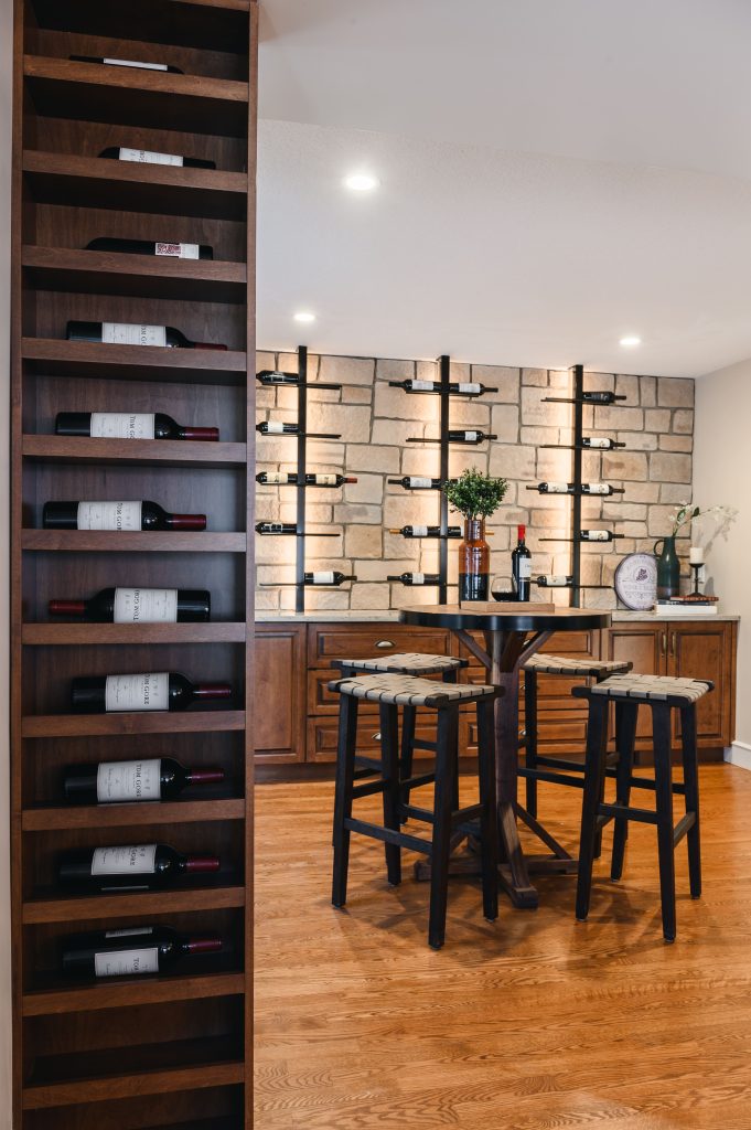 Tuscany Estate Interior Decorating Wine Tasting Room Tall Shelves Unshelf Design. Large wine room with hardwood floors and wood cabinetry accents.
