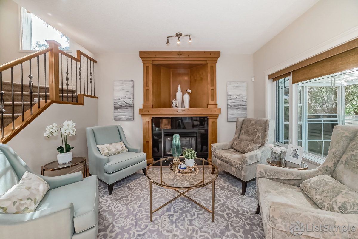 Transitional Inglewood Home Home Staging FEATURE IMAGE Unshelf Design. Open concept living room with floral chairs and modern table decor.