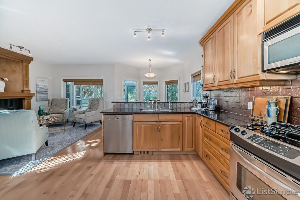 Transitional Inglewood Home Home Staging Kitchen and Breakfast Nook Wood Cabinets Unshelf Design. Open concept living room with a large kitchen that has stainless steel appliances.