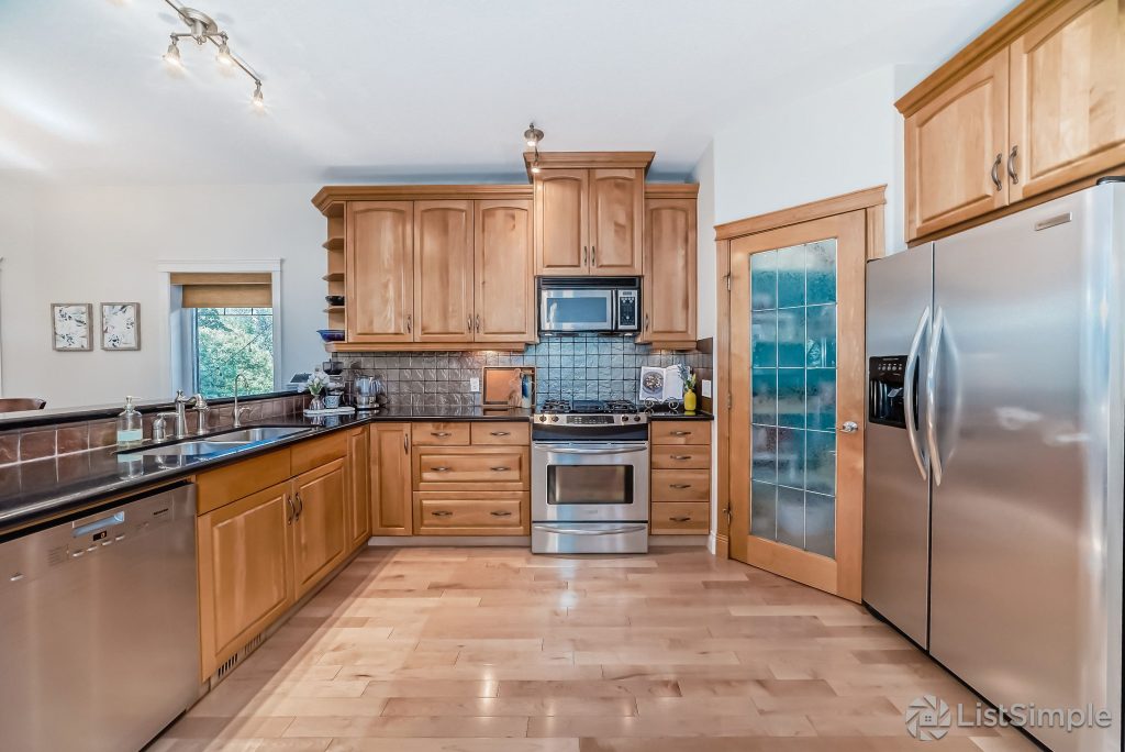Transitional Inglewood Home Home Staging Kitchen and Breakfast Nook Unshelf Design. Large kitchen with hardwood flooring and oak cabinets.