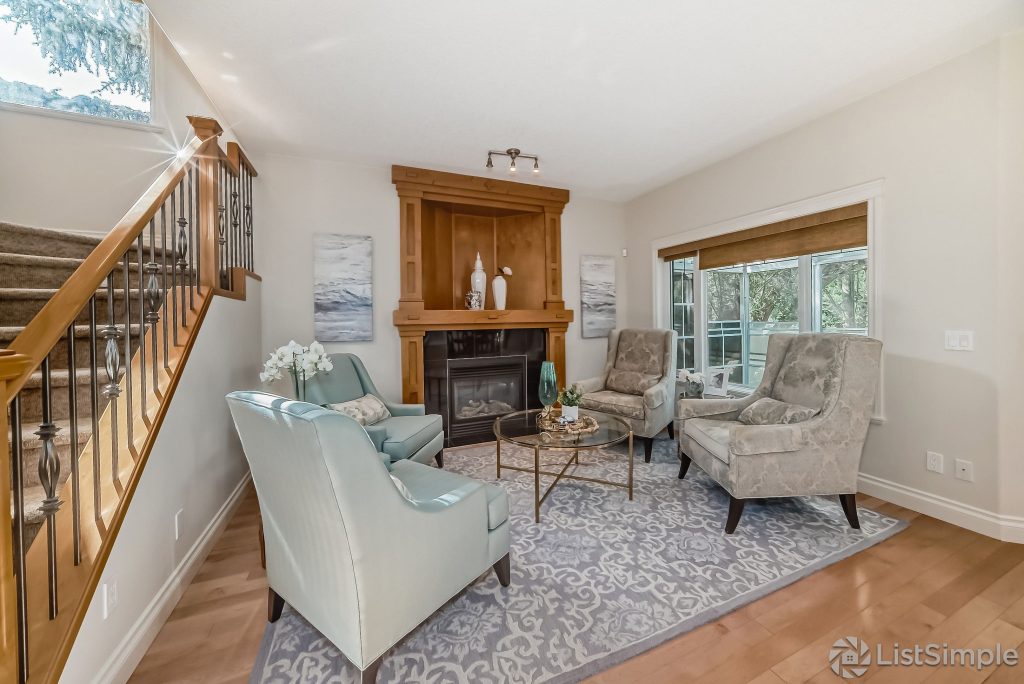 Transitional Inglewood Home Home Staging Sitting Room (Fireplace) Large Area Rug Home Staging. Light and bright sitting room with abstract blue and white artwork.