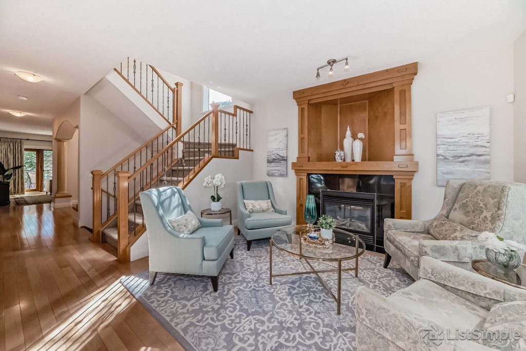 Transitional Inglewood Home Home Staging Sitting Room (Fireplace) Light Blue Chairs Unshelf Design. Large wood burning fireplace with modern decor on the fireplace mantel.