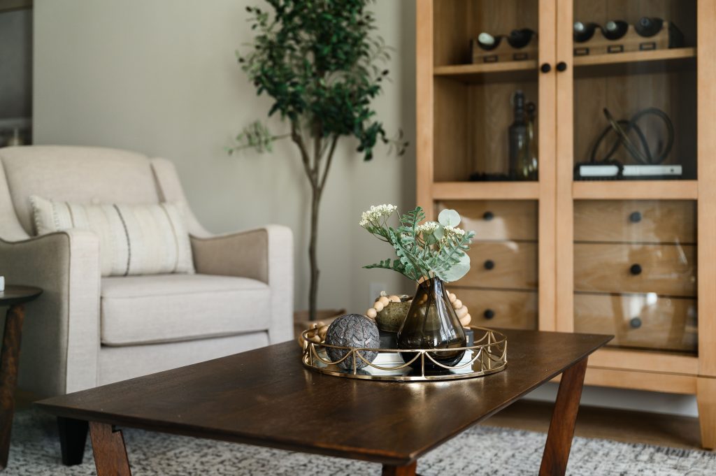 a large open concept living room styled with couches on each side wall, two chairs , side tables with lovely lamps, a styled coffee table and a large area rug to cover the space