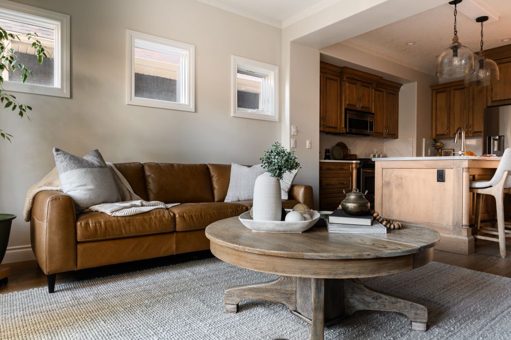 a large open concept living room styled with couches on each side wall, two chairs , side tables with lovely lamps, a styled coffee table and a large area rug to cover the space