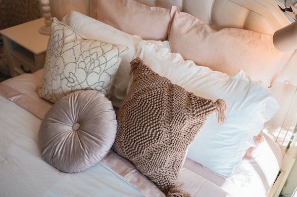 pile of textured pillows on bed