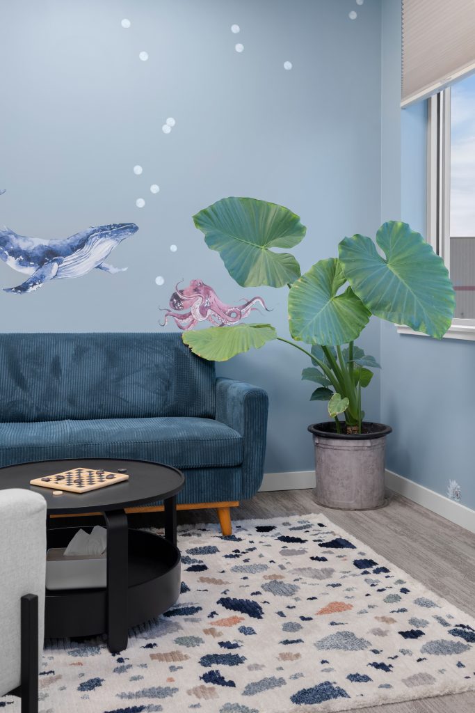 Psychology clinic commercial decorating blue playroom plants Unshelf Design. Giant taro plant in children's psychology office.