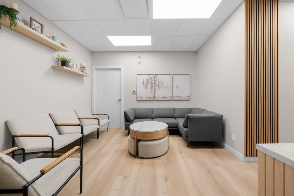 Psychology clinic commercial decorating bright waiting room Unshelf Design. Children's psychology clinic waiting area, grey couch and beige chairs.