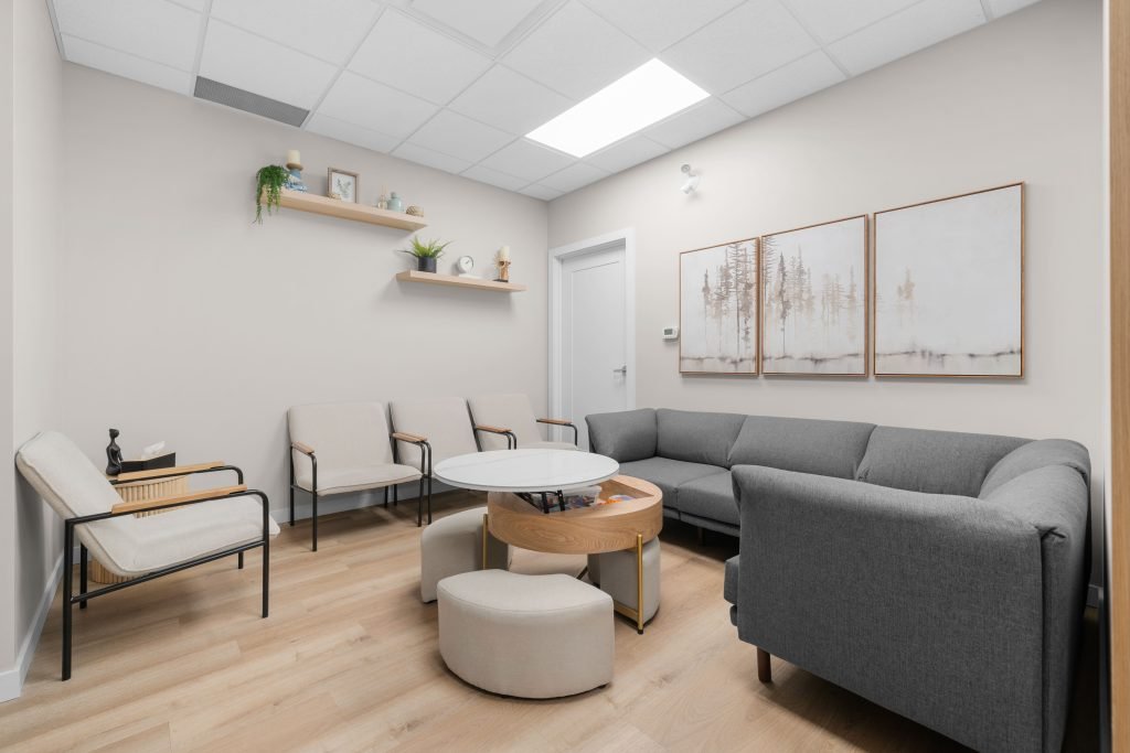 Psychology clinic commercial decorating waiting room Unshelf Design. Bright, open waiting room with couch, chair, and stool seating options.
