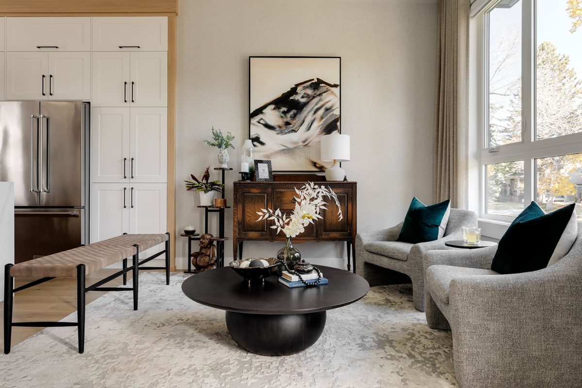 A wide photo of the sitting area of the home. Muted tones throughout, with pops of teal colored accents. Modern mountain design interior furnishing & decorating bright open sitting room Unshelf Design