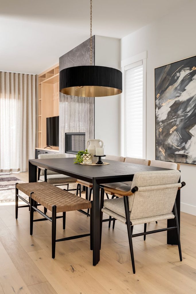 Side angle photo of a dark wood dining room table. Five dining chairs surround the table, with bench seating on one of the longer sides. Modern mountain design interior furnishing & decorating dark dining room table Unshelf Design