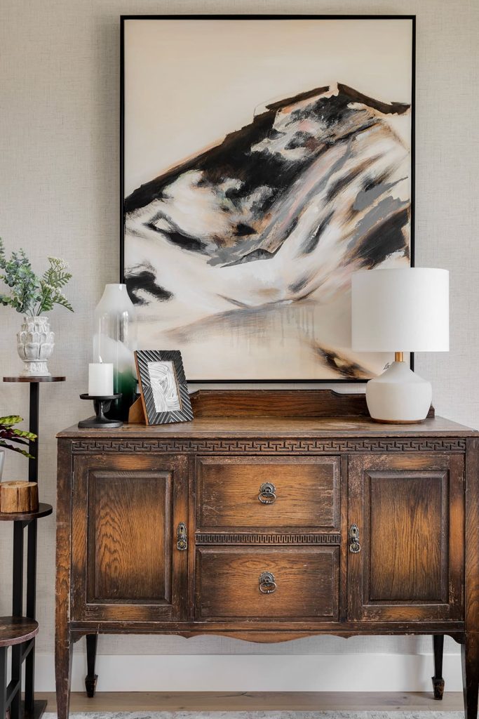 Sitting room cabinet with art hanging on the wall behind it. Modern mountain design interior furnishing & decorating living room storage and decor Unshelf Design
