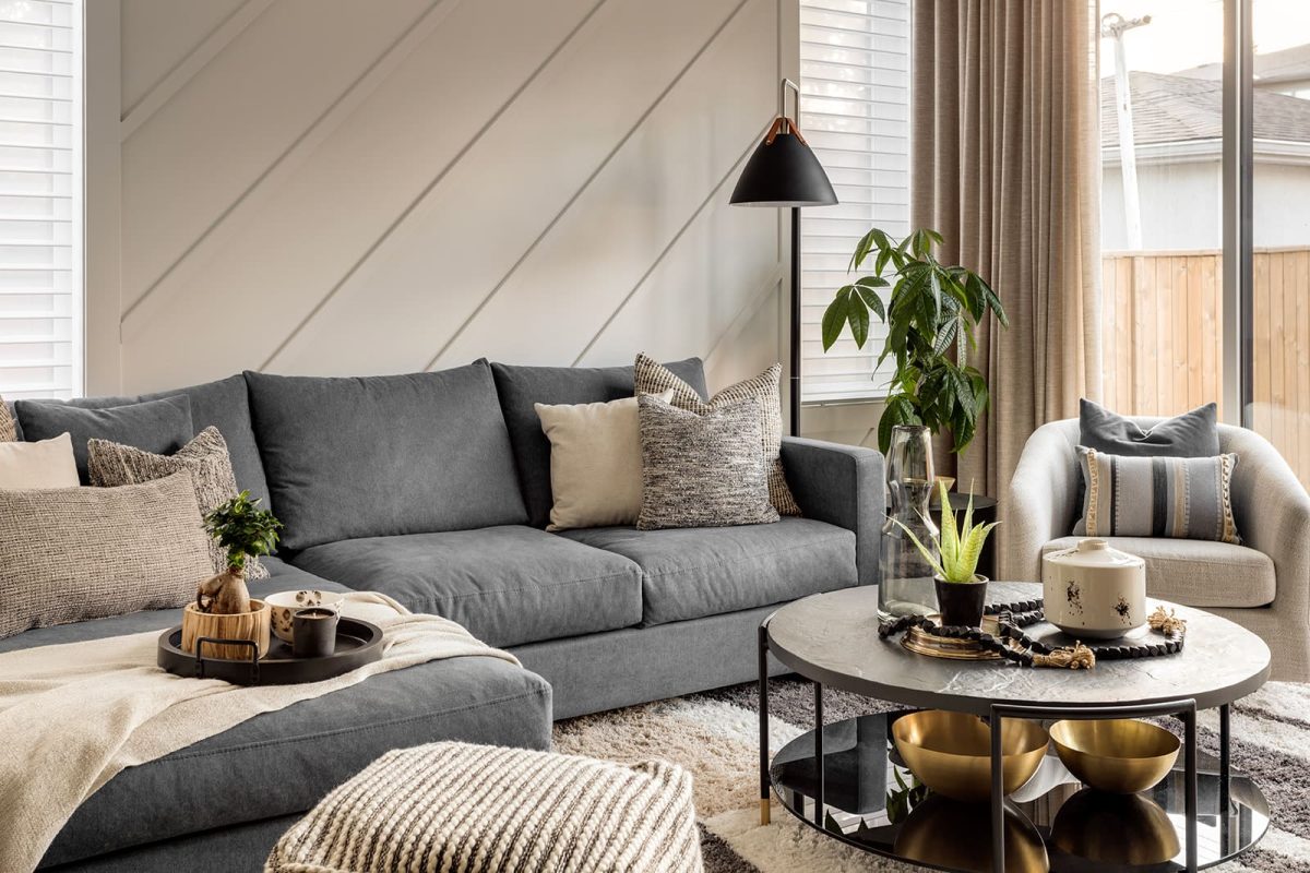 Grey couch and light grey chair with grey-toned pillows. Modern mountain design interior furnishing & decorating muted sitting room decor Unshelf Design