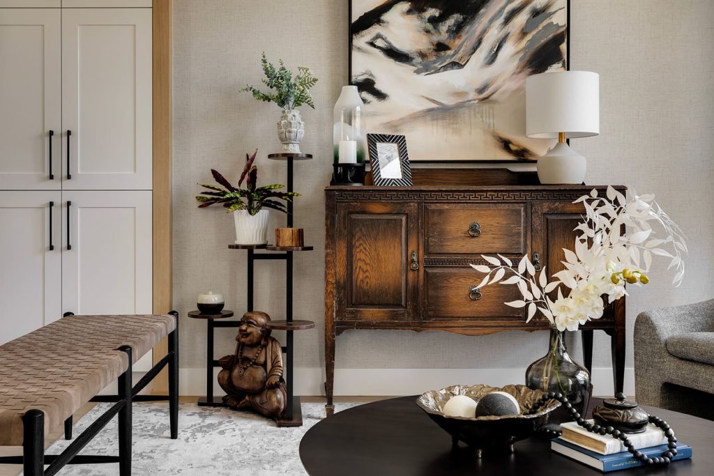 Dark round coffee table in foreground, with dark wood cabinet in background. Modern mountain design interior furnishing & decorating sitting room plant stand Unshelf Design