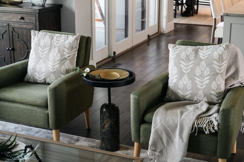 a large open concept living room styled with couches on each side wall, two chairs , side tables with lovely lamps, a styled coffee table and a large area rug to cover the space