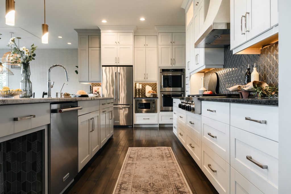 modern calgary kitchen with beautiful glass lighting fixtures, simple artwork and island chairs to match the cabinetry