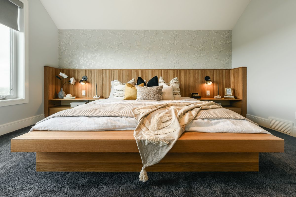 A master bathroom with a masasive standing shower with seating area styled with a lavender plant and a large bathtub styled with a shell, wood and plants