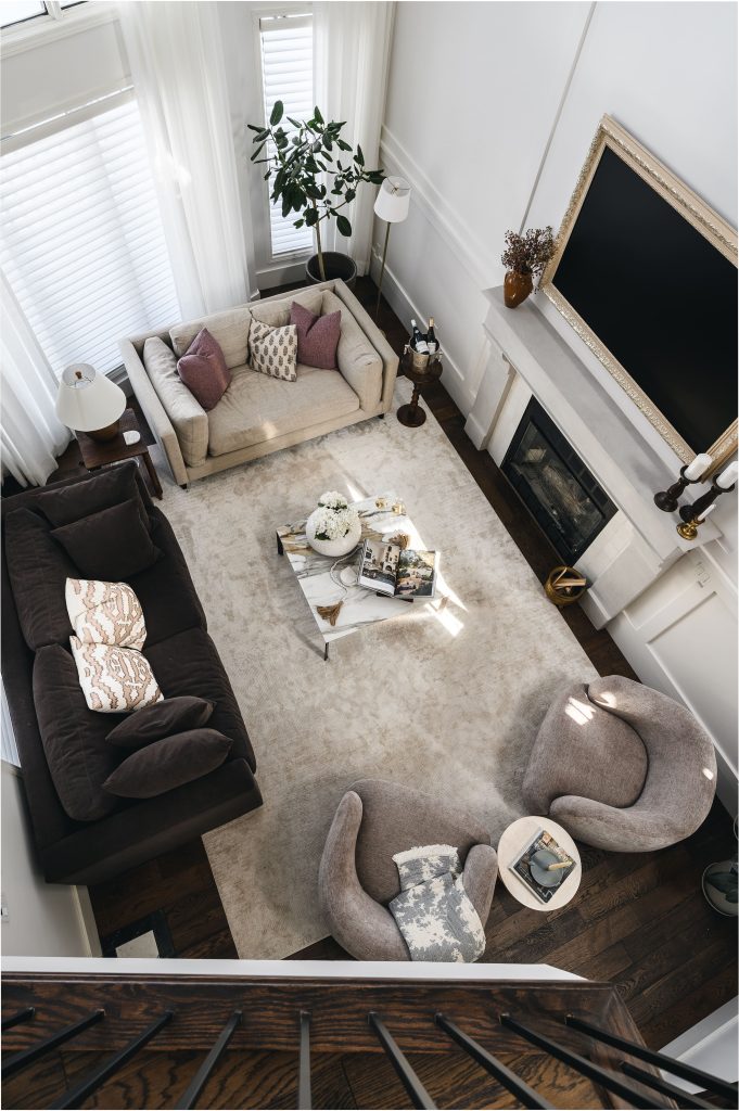 Bird's-eye view from the staircase in the living room showing the full furniture arrangement centred around the fireplace.