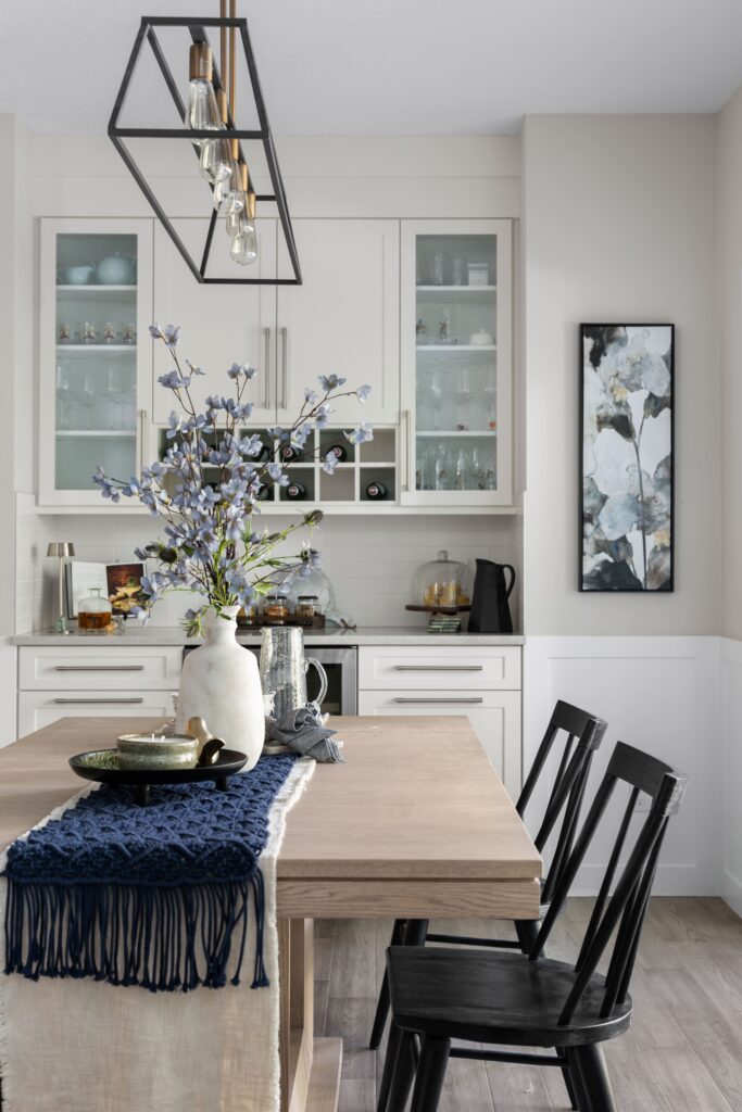 A closer look at the dining table centrepiece, with a blue floral arrangement set beneath the linear light fixture.