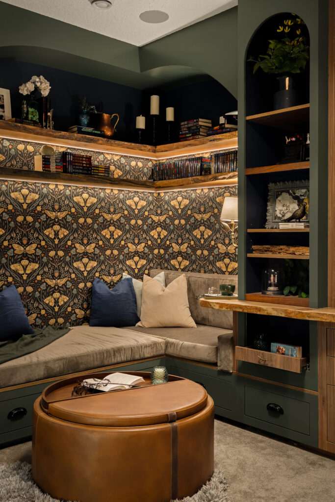 A corner reading nook with layered live edge shelving holding books, candles, and collected keepsakes.